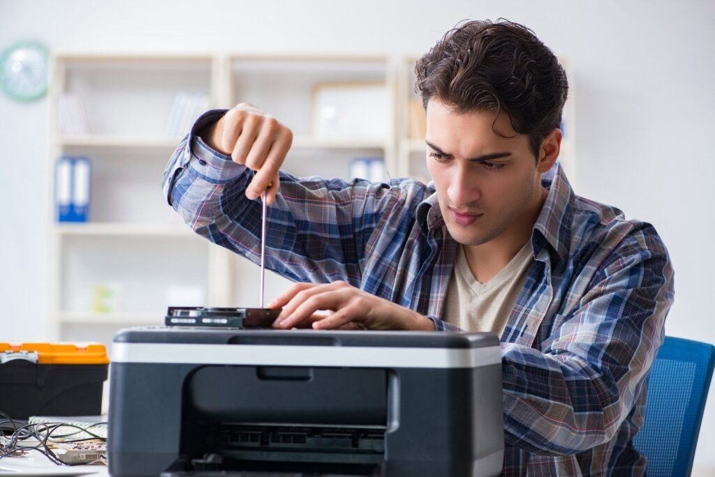Hardware repairman repairing broken printer fax machine
