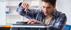 Hardware repairman repairing broken printer fax machine